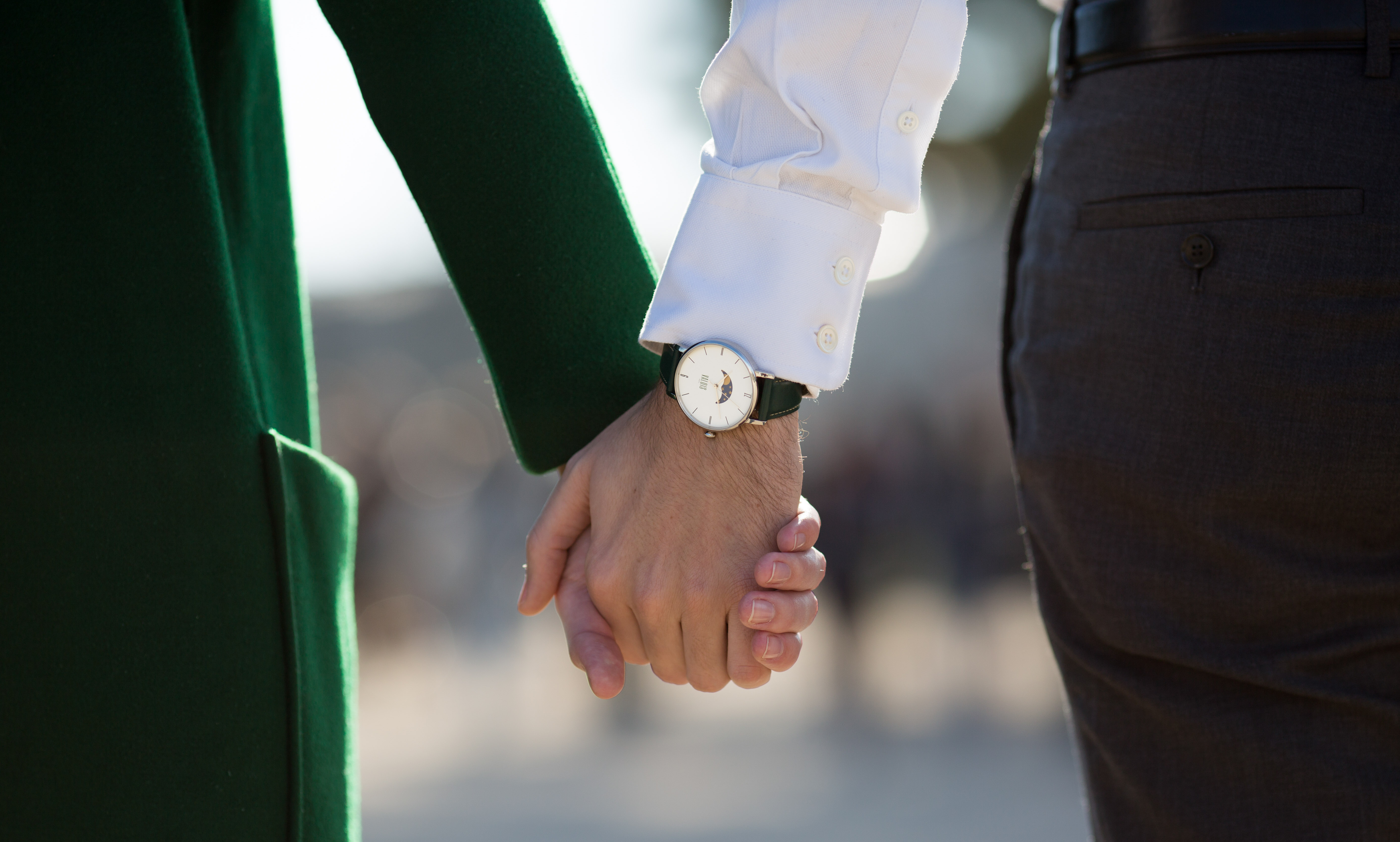 Montre Valois bracelet en cuir vert portée par un homme tenant la main à sa femme