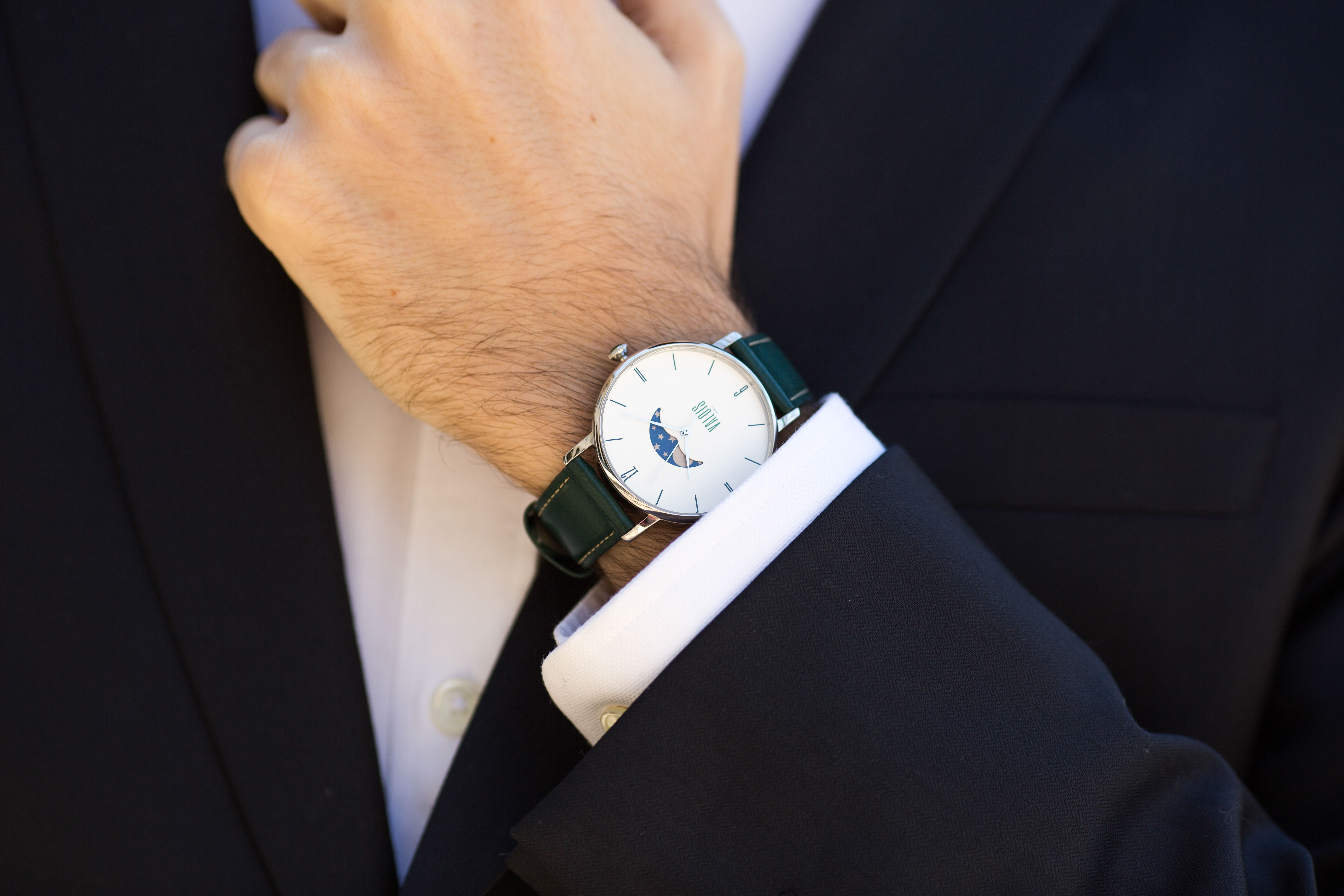 Montre Valois bracelet en cuir vert portée par un homme en costume