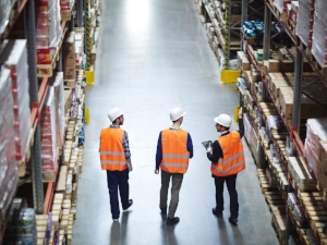 Three Workers Walking Through Warehouse