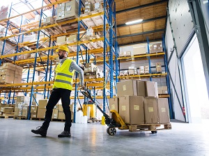 Warehouse Worker Pulling Pallet Jack Near Loading Dock