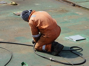 Welder Kneeling Down to Finish Work