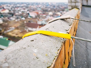 View of ropes supporting a suspended scaffold that are protected from fraying.