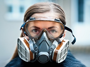 A worker wearing a respirator and safety goggles.