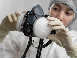 Worker inspecting a respirator.