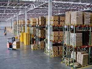 A forklift in a warehouse with pallet racks.