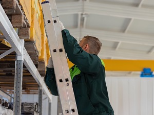 Warehouse worker climbing a ladder.