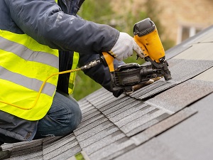 Worker on roof making repairs.