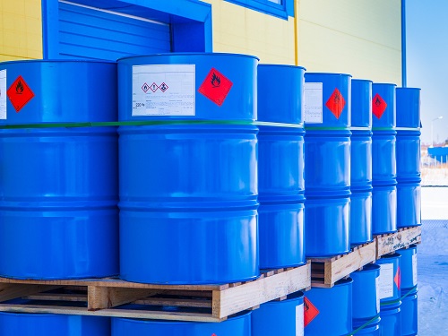 Stacked, blue, 55-gallon drums that contain a hazardous substance.
