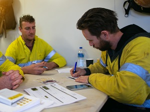 Two workers filling out forms.