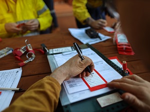 A project manager filling out a tagout device in preparation for lockout tagout process.