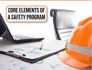 A desk with a hardhat, laptop computer, and papers with a banner that says Core Elements of a Safety Program.