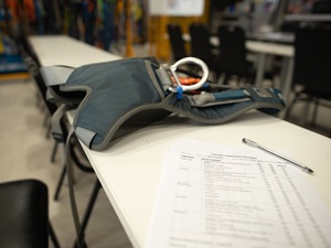 A checklist on a desk, someone is completing a body harness inspection.