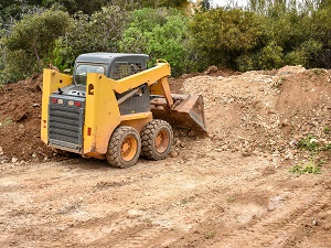 A skid-steer loader in operation at a job site.