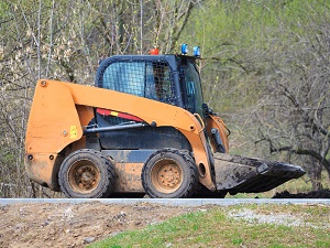A skid-steer loader in operation at a job site.