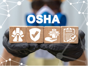 A person wearing safety gloves holds four wooden blocks with icons representing safety gear, a shield, health monitoring, and documentation, with the word “OSHA” in bold white letters above.