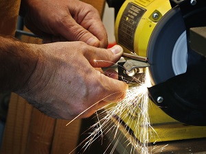 Worker Using Bench Grinder