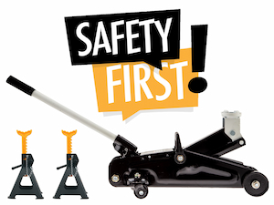 A black hydraulic floor jack next to two jack stands with yellow tops, in front of a “Safety First” sign on a white background.