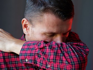 Man Coughing into His Elbow