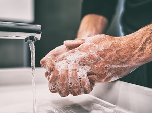Person Washing Hands with Soap and Water