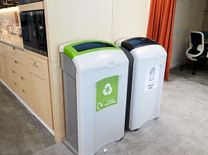 Trash and recycle containers outside of a corporate break room.