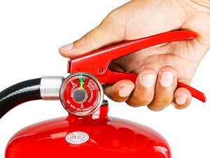 Person Holding a Portable Fire Extinguisher, Ready to Use