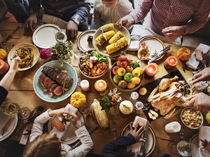 Family around table with a lot of food celebrating Thanksgiving.