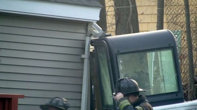 Close-up view of the excavator that rolled backwards hitting the house.