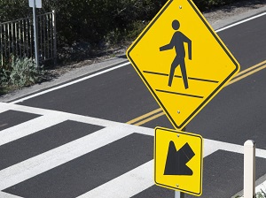A yield for pedestrians sign at a crosswalk.