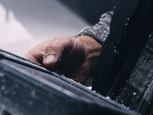 A worker using a digital pad but there is dust on their clothing, hands, and the pad.
