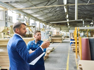 A worker and a supervisor completing a hazard assessment in a factory facility.