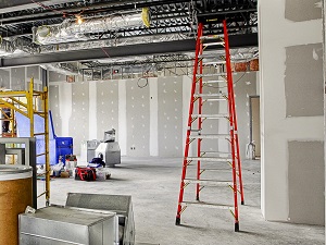 Portable step ladder at indoor construction site.