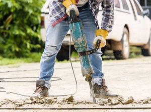Worker using a jackhammer on a construction site.