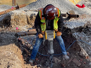 Worker using a jackhammer on a construction site.