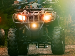 All-terrain vehicle in operation with the headlights on.