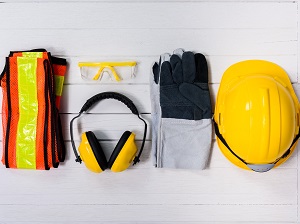 PPE including a safety vest, ear muffs, safety glasses, work gloves, and a hard hat.
