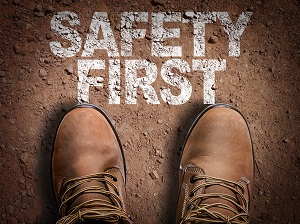Work boots on dirt with a sign that says Safety First.