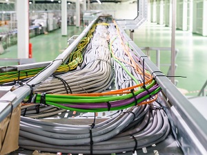 Cable tray filled with routed cables in an industrial workplace.