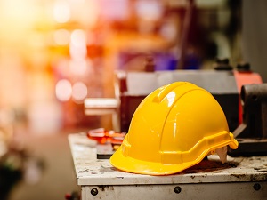 A hardhat on a work bench in an industrial work environment.