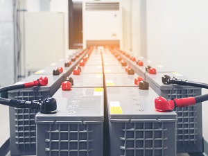 Two rows of industrial batteries in use in an industrial workplace.
