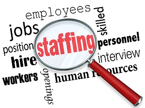 A word cloud built around the word Staffing with a magnifying glass on top.