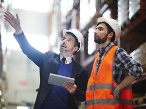 A warehouse supervisor training a new employee.