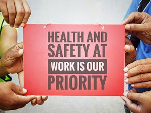 Several workers holding up a sign that says, "Health and Safety at Work is our Priority."