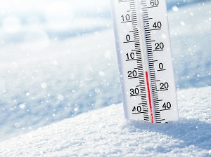 A thermometer in the snow indicating that there are freezing temperatures.
