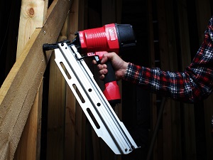 A construction worker using a nail gun.