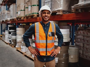 A confident small business owner standing in a warehouse.