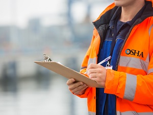 OSHA inspector holding a clipboard.
