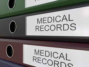 Medical records in large binders that are stacked.