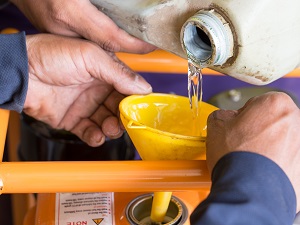 Two people pouring fuel into a generator safely.