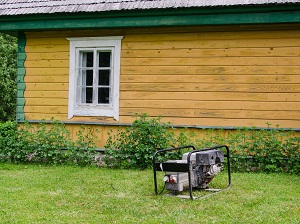 Older generator sitting outside of a house.