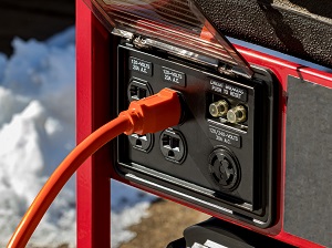 Close-up view of an extension cord plugged into a generator.